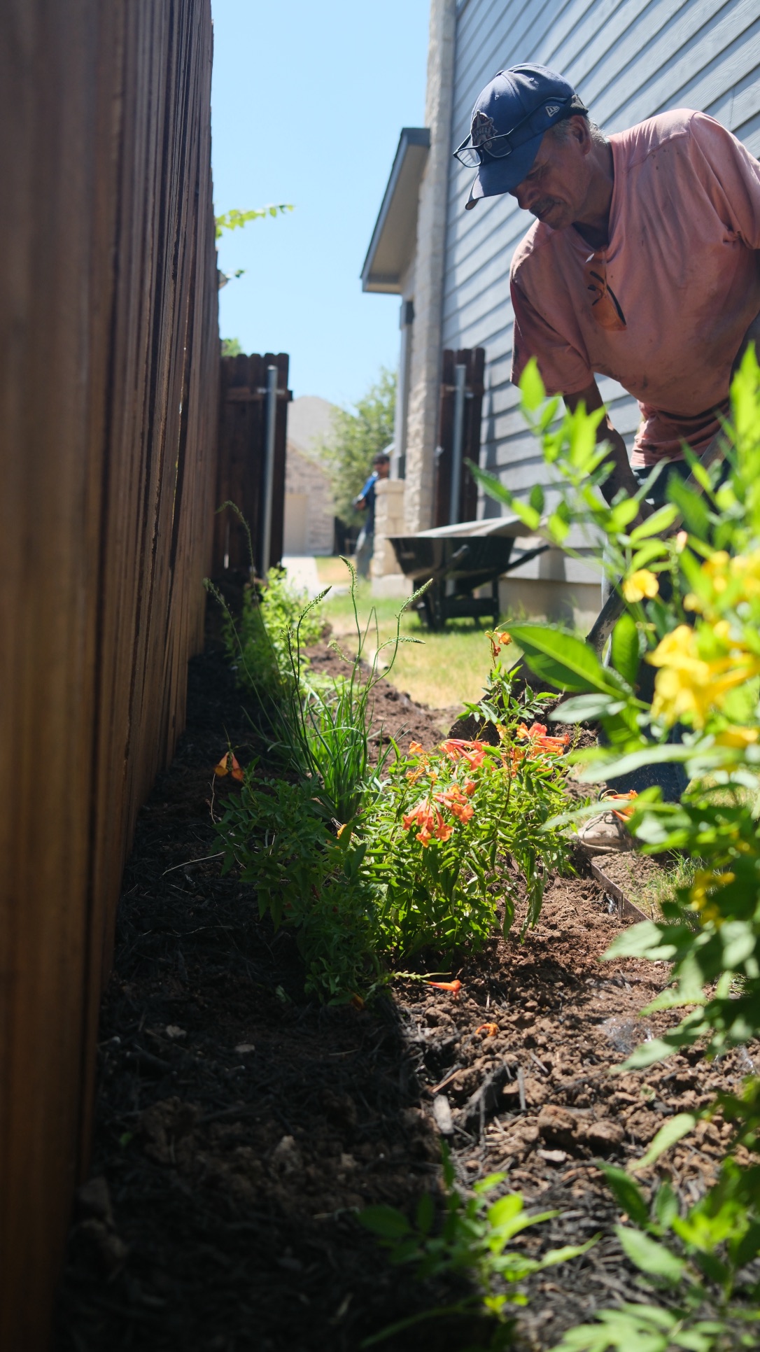 Gonzalo Sr. tending a garden bed beside a Central Texas home